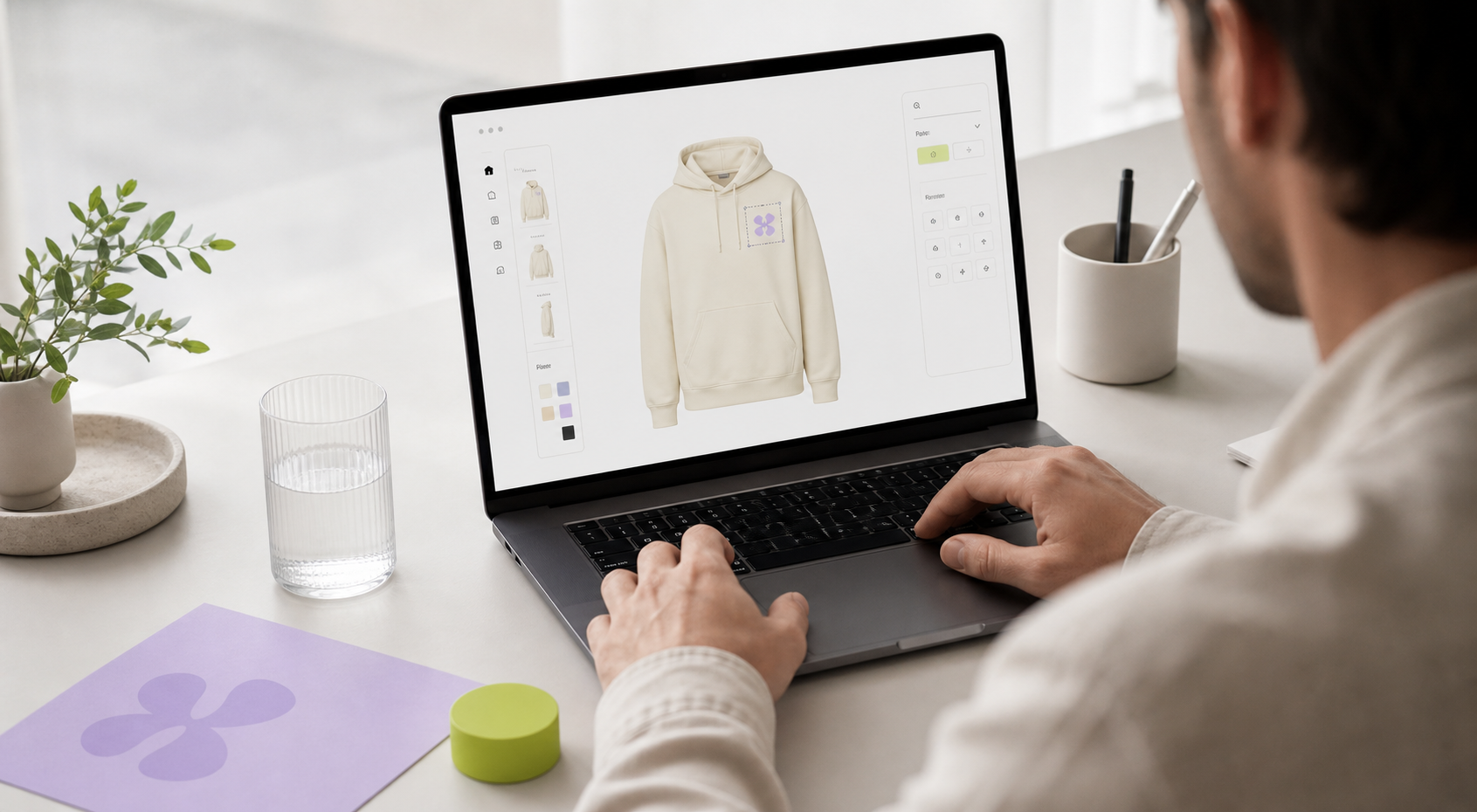 Promotional product designer building a cream hoodie mockup on a laptop